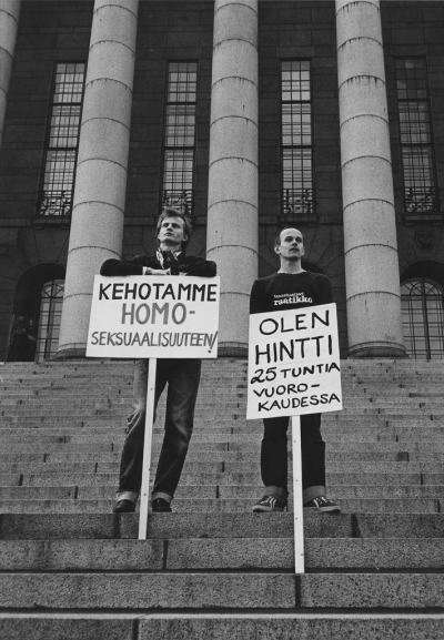 Two men with signs at the stairs of parliament house 